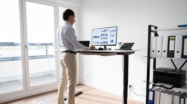 man standing at an elevated desk