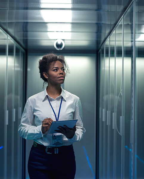 women with a tablet standing in a computer server room