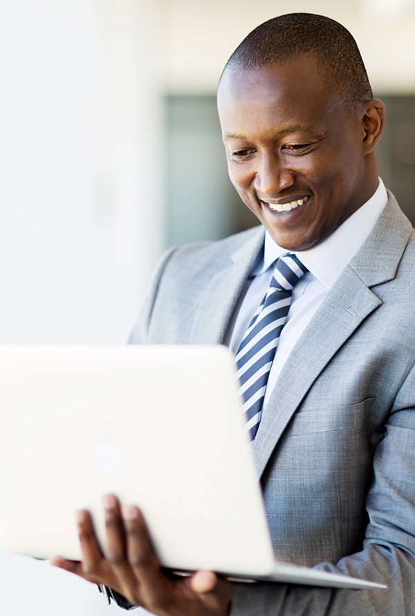 smiling man holding laptop in his arm